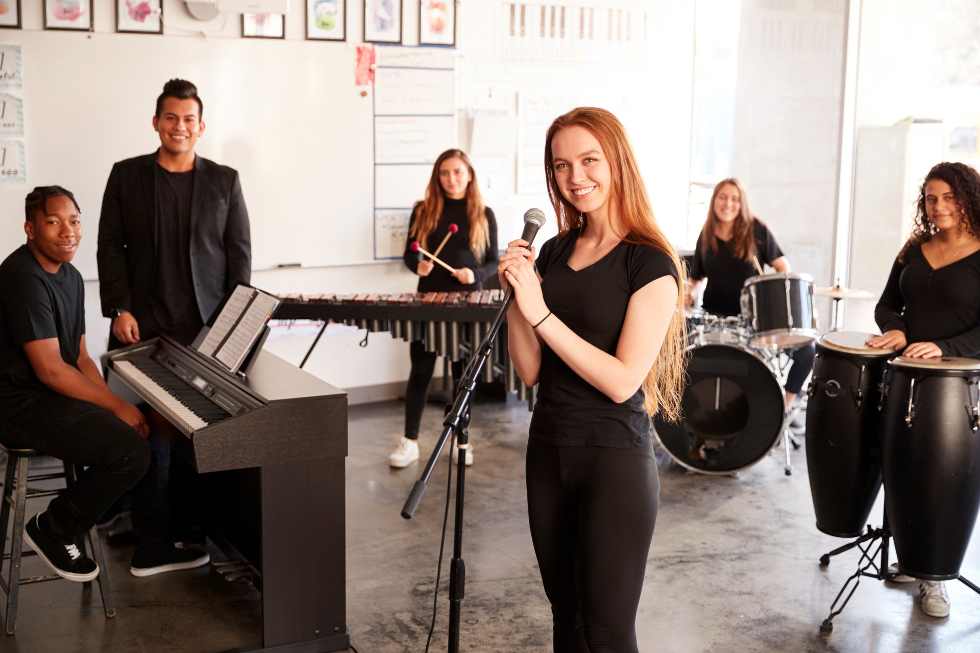 Portrait Of Students At Performing Arts School Playing In Band At Rehearsal With Teacher